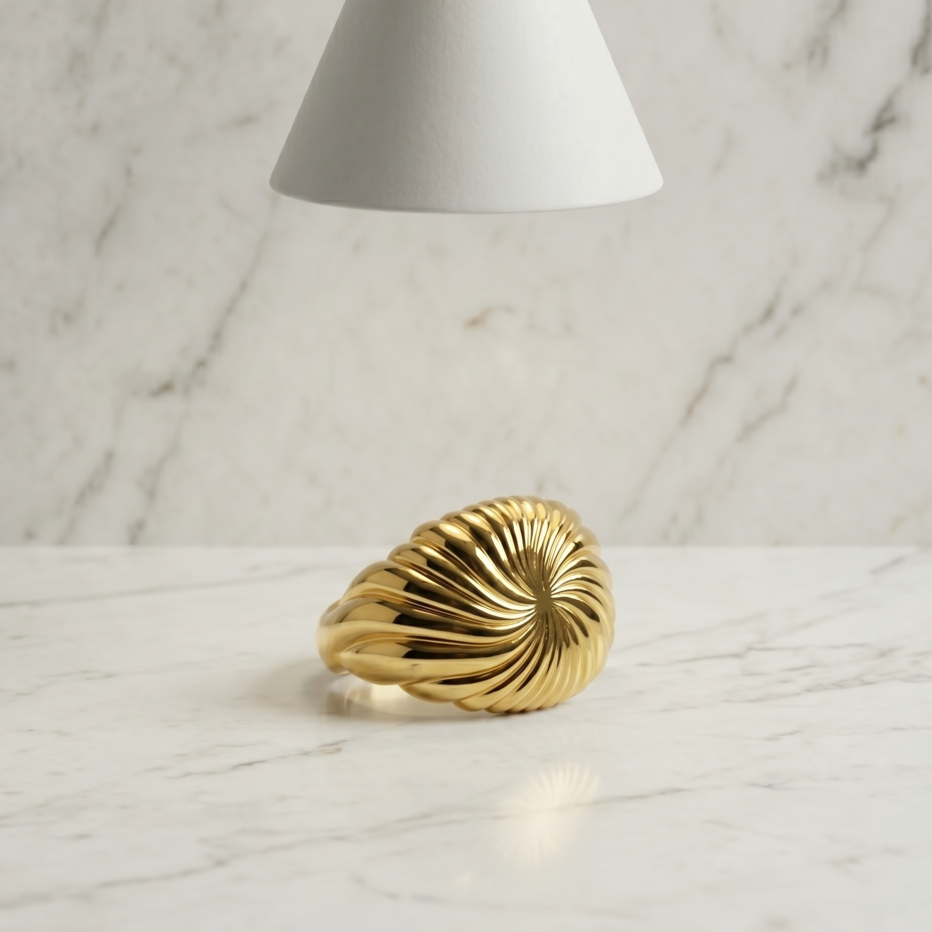 Gold ring on a marble surface with a soft light source