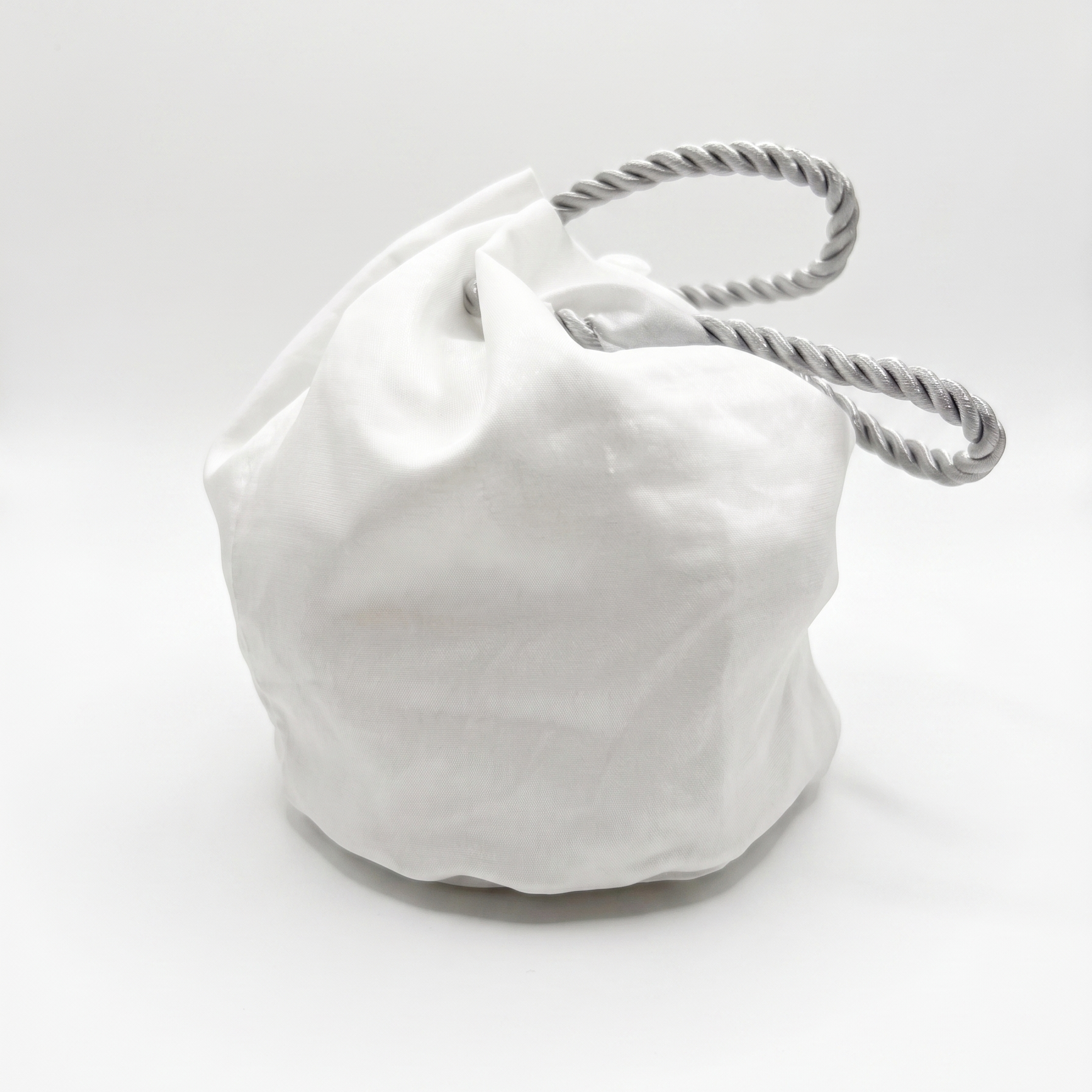 White drawstring bag with a rope handle on a white background