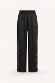 Black wide-leg silk trousers with sheer lace side panels, shown against a plain light background.